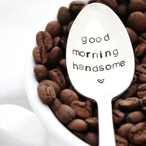 A spoon with the words good morning on the coffee beans